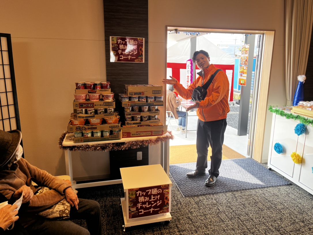 カップ麺積み上げチャレンジブースで対応するスタッフの様子