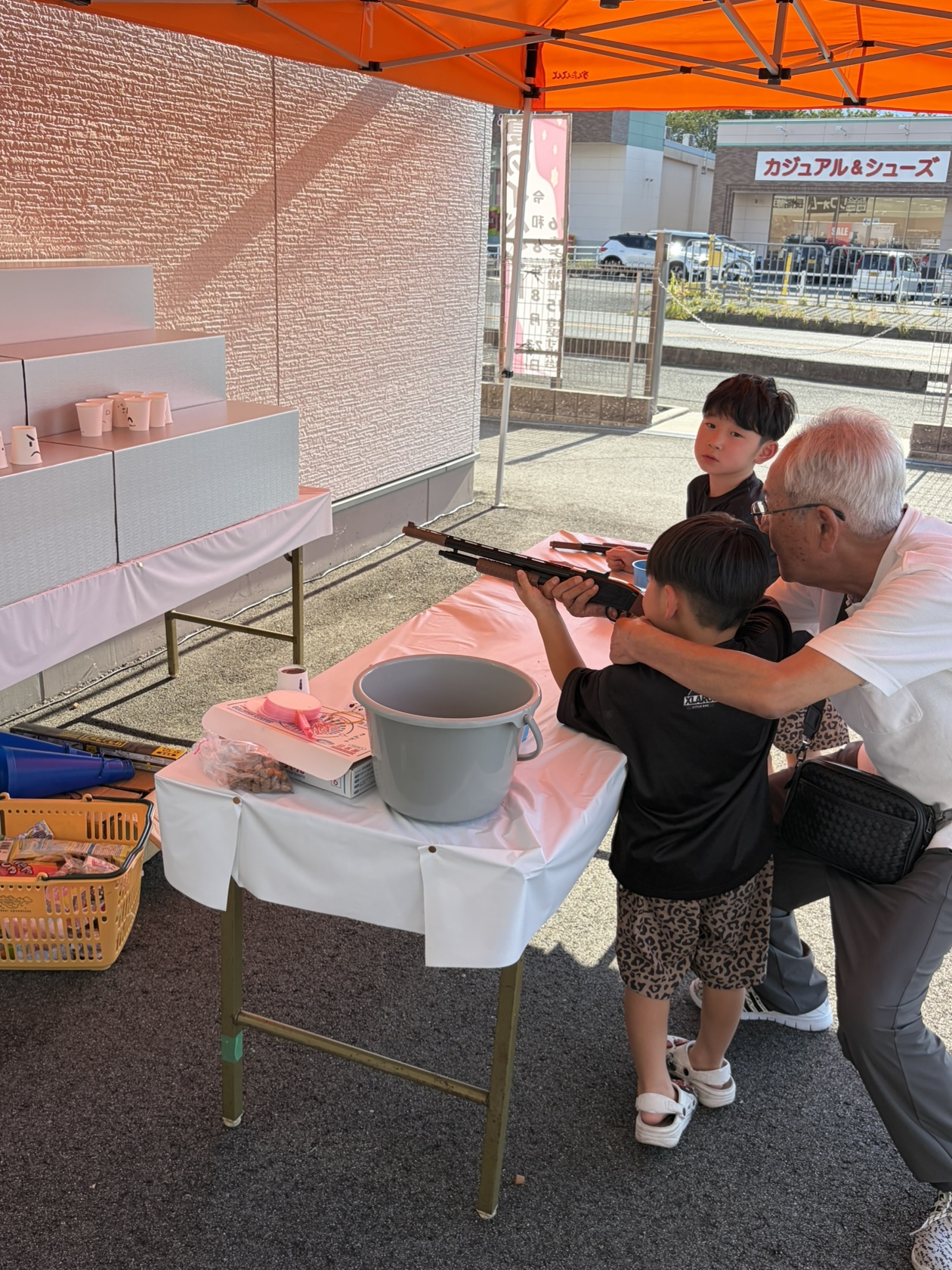 夏の思い出イベントの射的を家族で楽しむ様子