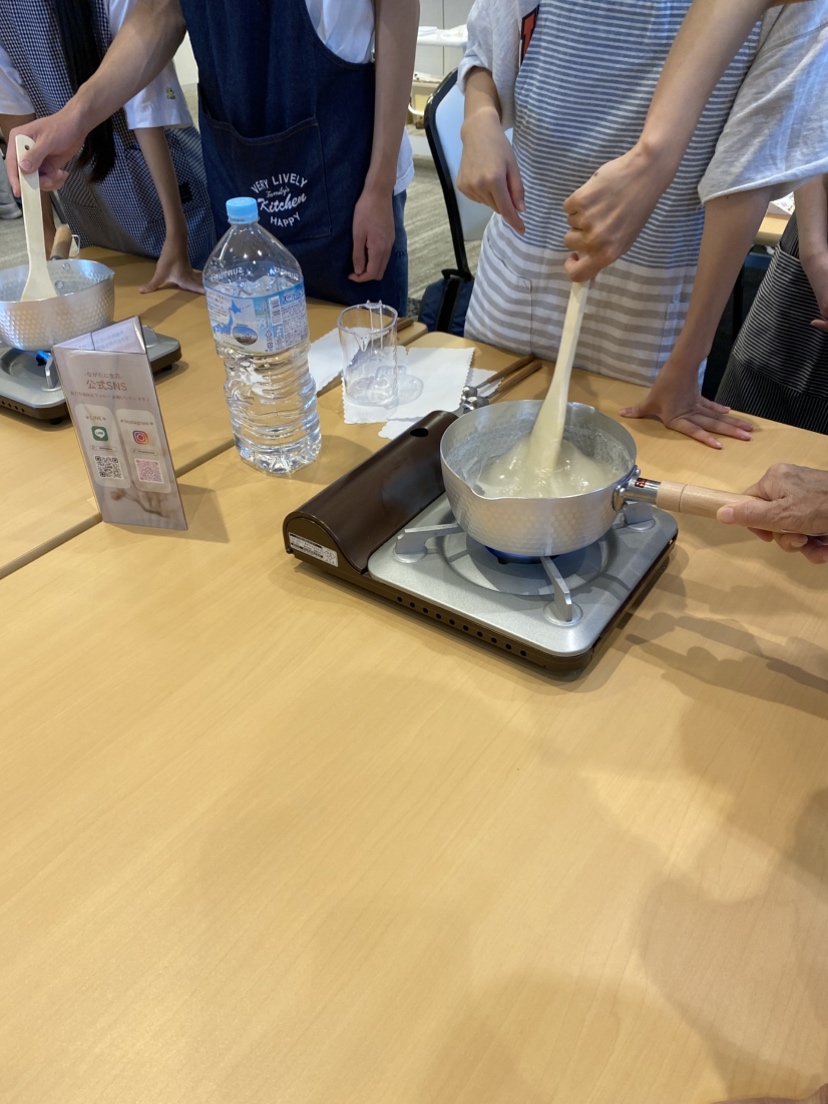 鍋に入れた葛を木べらで練りながらくずもちを作る様子